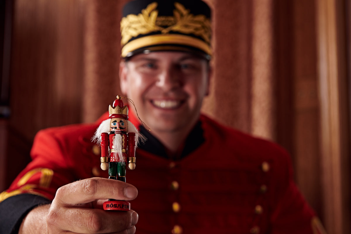 A Treasy Nutcracker delivering a Christmas tree to a family